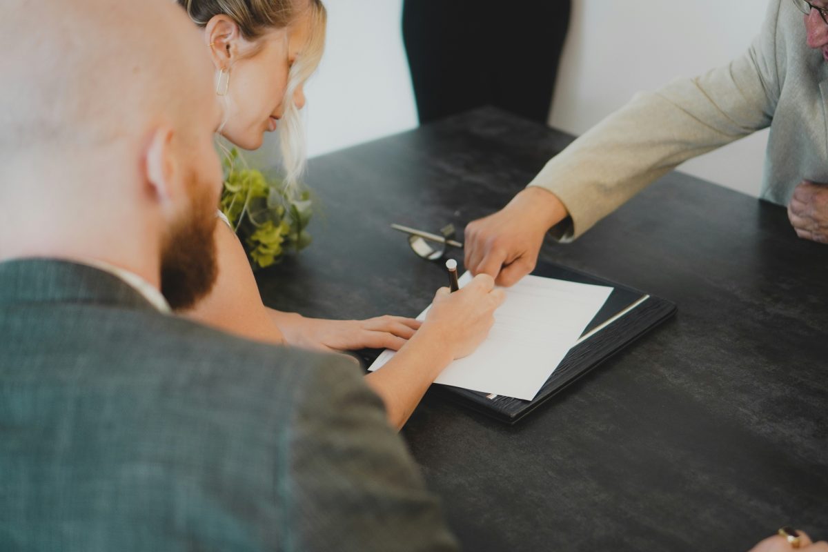 A financial advisor guides a client through signing important documents