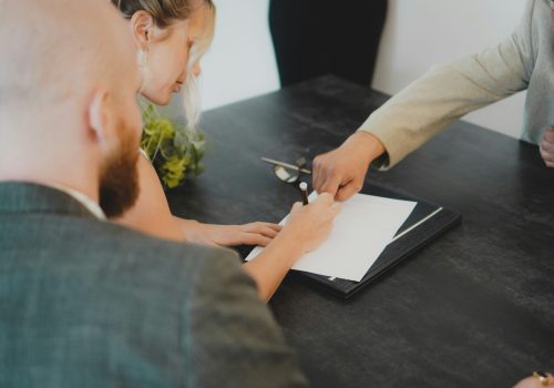 A financial advisor guides a client through signing important documents